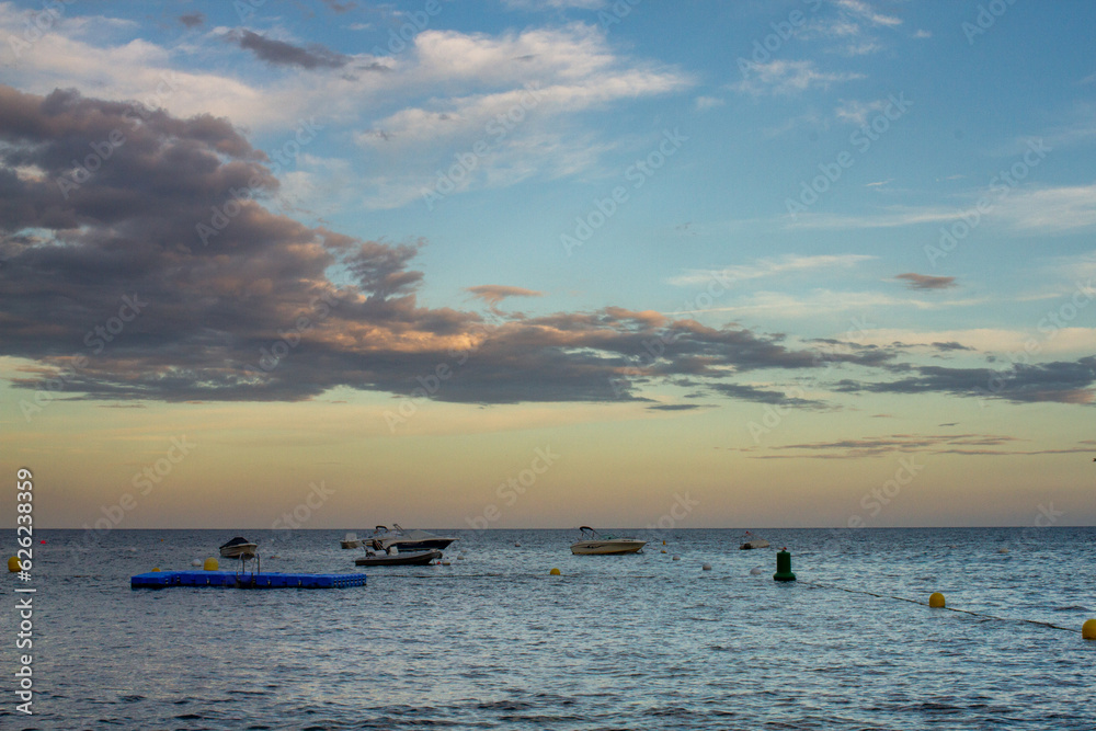 Experimenta la serenidad mientras el sol se sumerge bajo el horizonte, arrojando un brillo dorado sobre la playa tranquila. Contempla la obra maestra de la naturaleza.