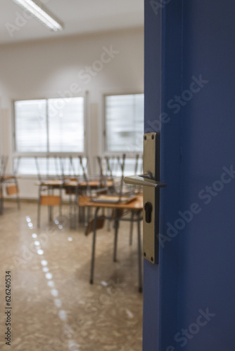 The door open of a school, with the tables in the background, back to school