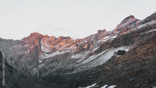 Spectacular view of the Refuge des Serradets with Cirque du Gavarnie at the background and with snow covering the hills at sunset