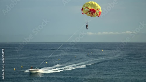 girl on a parachute attached to a motorboat