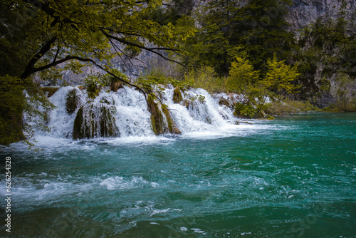 Fototapeta Naklejka Na Ścianę i Meble -  Wodospad spływający do pieknego turkusowego jeziora w Plitvickim Parku Narodowym.
