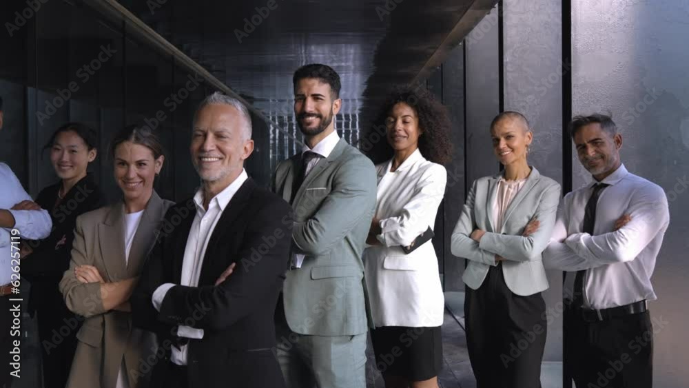 Multicultural business team headed by mature male boss. Posing to camera cheerfully with crossed arms at the office. Multicultural business team headed by mature male boss. Posing to camera cheerfully with crossed arms at the office.