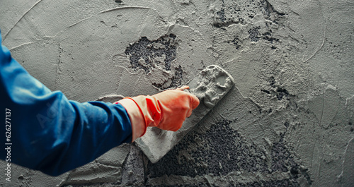 Fotografering hand of worker plastering cement at wall for building house
