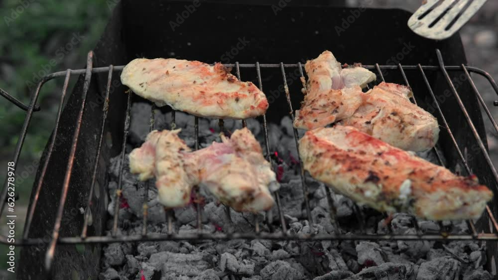 Chicken Fillet Bbq. Grilled Chicken Breast on the hot Grill with Smoke and Fire Flames. Juicy White Meat Steak. Delicious Poultry Roasted Cooked on a Charcoal Barbecue. Camping Food. Outdoors Cooking Chicken Fillet Bbq. Grilled Chicken Breast on the hot Grill with Smoke and Fire Flames. Juicy White Meat Steak. Delicious Poultry Roasted Cooked on a Charcoal Barbecue. Camping Food. Outdoors Cooking