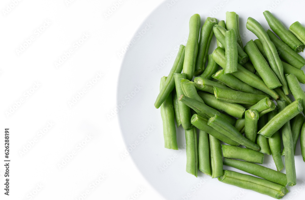 Fresh chopped green beans in a round plate, on a white background. top view 