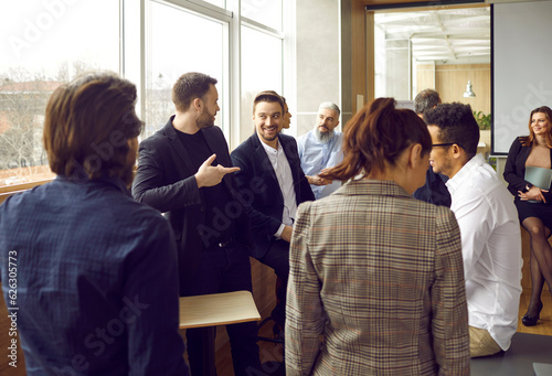 Fotografi Big group of happy smiling diverse people talking while standing in an office ro