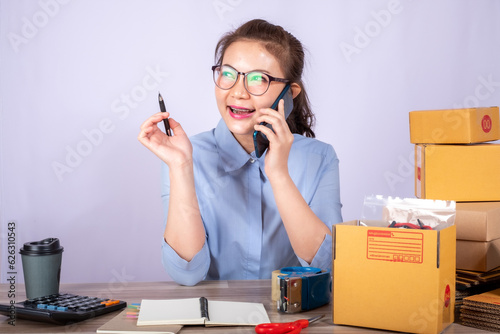 Asian woman owned business SME entrepreneur of Young Asian women working with Boxs laptop and phone for Online seller shopping at home