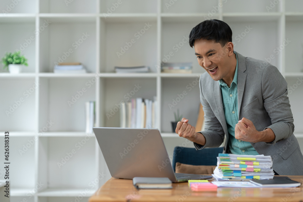 confident young businessman Happy smart gesture excited with laptop computer and raised arms to celebrate happy financial business success startup business ideas.