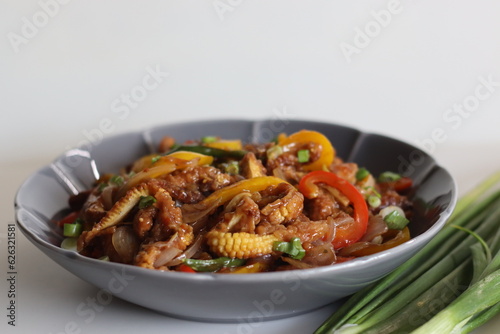 Baby corn chilly. An Indo Chinese dish with crisp fried baby corn in a spicy sauce with sauteed onions and bell peppers.