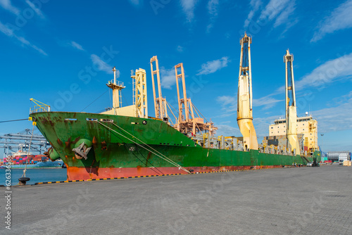 Unloading operation of project  cargo with port heavy lift cranes A crane on a large cargo ship docks loading a new diesel-electric locomotive.  at Laem Chabang Port photo