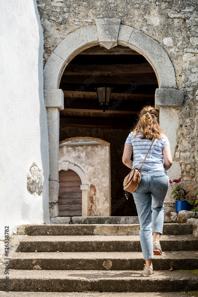 Young tourist woman walking through the old, beautiful Brsec town streets, located on istrian peninsula, Croatia