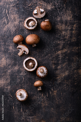 Raw champignon mushrooms on black background