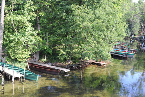 Beautiful summer landscape with river and wooden boats in the forest in summer