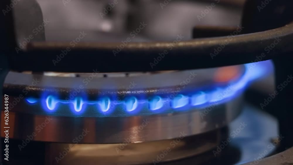 Close-up view of blue flame ignited appearing from gas stove. Fire of modern conveniences. Economic crisis. Shortage of fuel. stove burner. Gas ring. Stove top. Close-op footage gas stove.