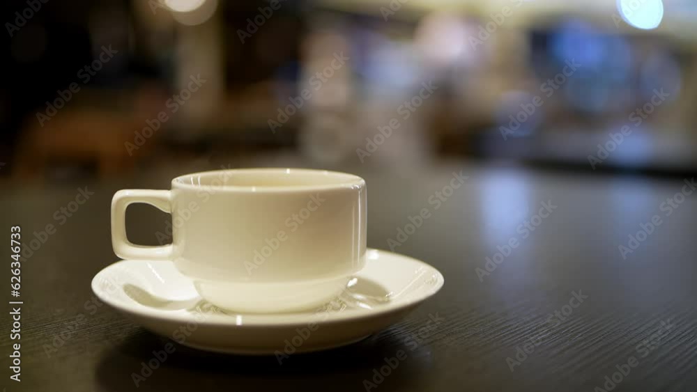 Hot cup of coffee with steam on a blurry background of people passing by, eating breakfast at a hotel. Hot cup of coffee with steam on a blurry background of people passing by, eating breakfast at a hotel.