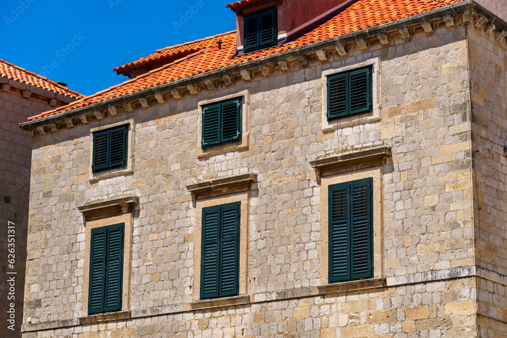 street view of the old town of Dubrovnik in Croatia, medieval European architecture, city streets, windows with wooden shutters, red tiled roofs, the concept of traveling in the Balkans