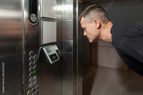 Obraz na płótnie A man shows his face to a fingerprint access control terminal with a facial recognition function installed in the elevator w salonie