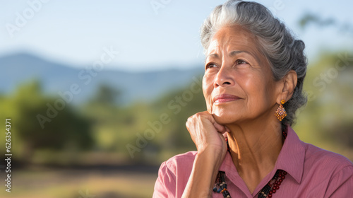 Elderly woman in a pensive pose in the nature background.