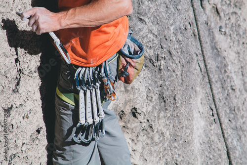 Rock climber using gear on the wall
