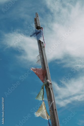 Tibetan prayer flags on post with clouds