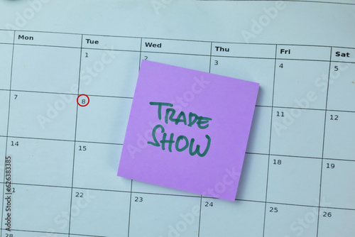 Concept of Trade Show write on sticky notes isolated on Wooden Table.