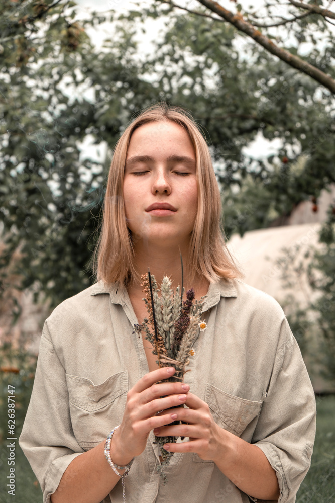 Woman Inhaling Incense Smoke During Meditation.Ground level of relaxed