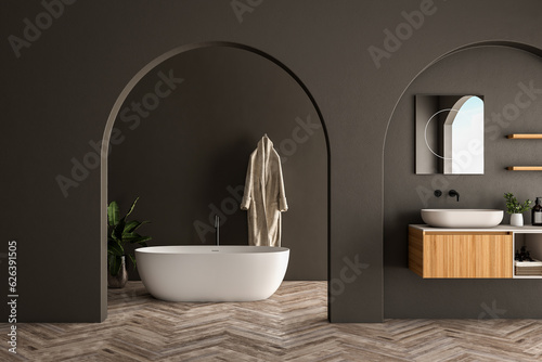 Modern bathroom interior with wooden vanity  bathtub  parquet floor  black walls  arches  plants