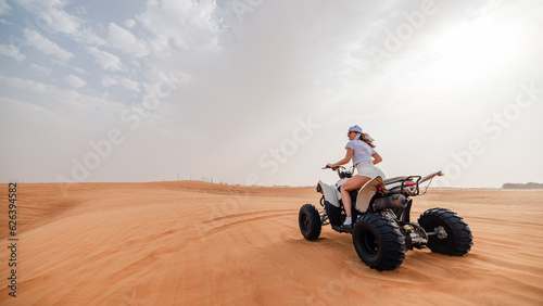 Woman riding sand dunes ATV in the Dubai desert