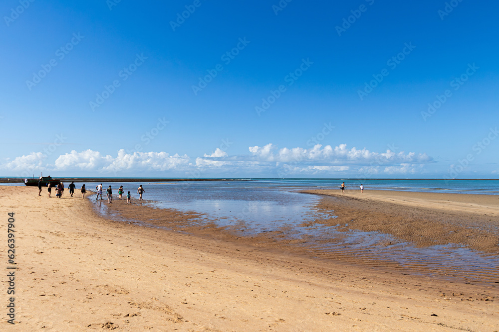 People Walking on the Path of Moses. Phenomenon realized by the meeting of the River with the Sea at Praia de Coroa Vermelha in Porto Seguro, Bahia, Brazil