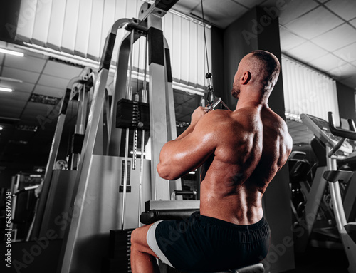 Strong Bodybuilder Doing Heavy Weight Exercise For Back On Machine in gym