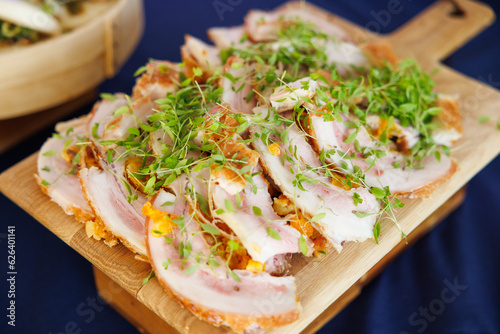 Sliced chicken on chopping board with greens