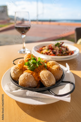 Canary Islands dish Papas Arrugadas wrinkly salty potatoes with and Mojo picon red spicy sauce. photo