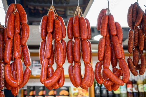 Spanish sausages chorizo hanging on butchers shop on farmers market