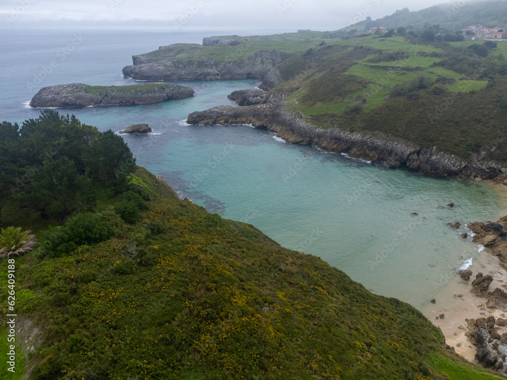 Obraz premium Aerial view on Playa de Toro in Llanes, Green coast of Asturias, North Spain with sandy beaches, cliffs, hidden caves, green fields and mountains.