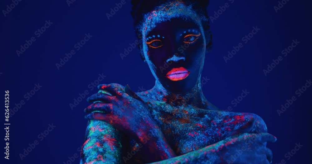 sexy woman in fluorescent paint makeup hugging herself close up portrait Slow motion isolated dark background