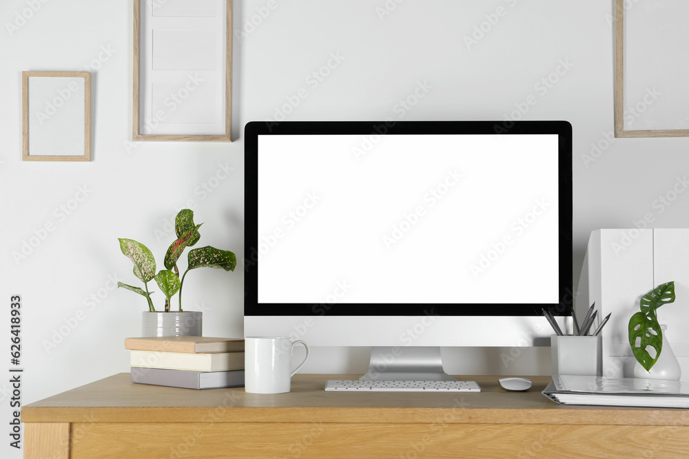Home workplace. Computer, stationery and houseplants on wooden desk Home workplace. Computer, stationery and houseplants on wooden desk