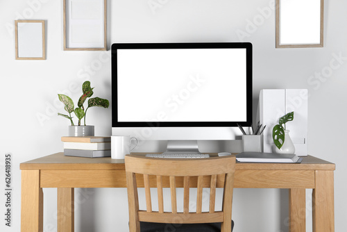 Home workplace. Computer, stationery and houseplants on wooden desk