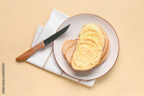 Plate of tasty toast with butter on yellow background