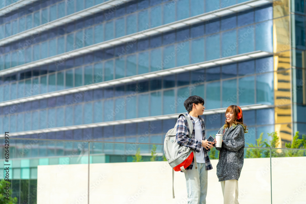 Happy Asian man and woman college student with backpack walking with talking together in the city. Young people generation z enjoy and fun university life with friends. Education and city life concept Happy Asian man and woman college student with backpack walking with talking together in the city. Young people generation z enjoy and fun university life with friends. Education and city life concept