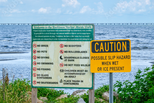 Caution Sign and Rules for Using the Bucktown Harbor Marsh Walk along Lake Pontchartrain in Jefferson Parish, Louisiana, USA photo
