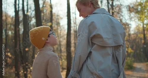 back rare view of happy blonde woman and her cute child boy running in the park Slow motion photo