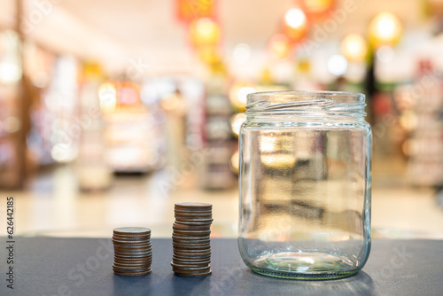 Coins in glass jars on table against blurred background concept of savings