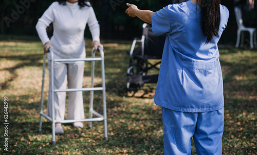 young asian physical therapist working with senior woman on walking with a walker