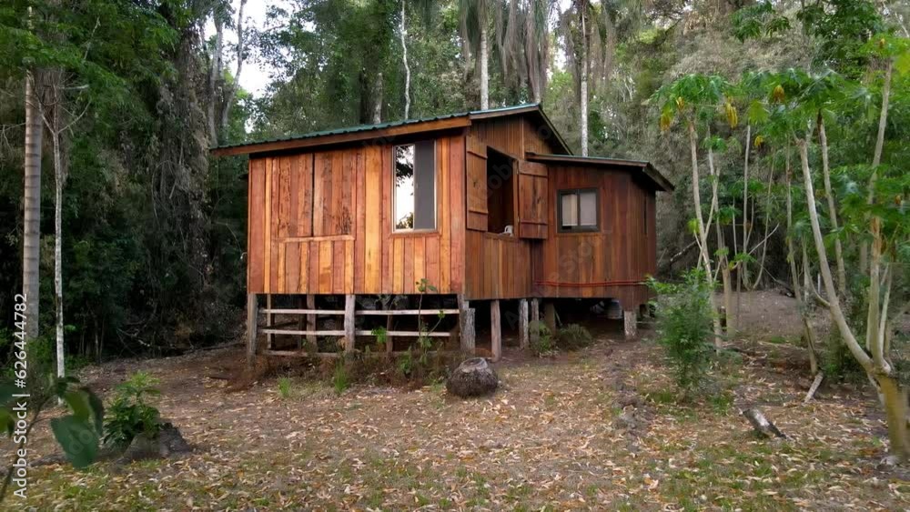 Steady drone shot flying towards a wooden forest cabin in the rainforest of Misiones, Argentina. Steady drone shot flying towards a wooden forest cabin in the rainforest of Misiones, Argentina.