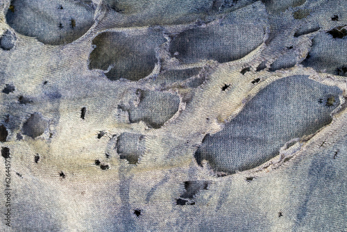 Close-up of the texture of a cotton cloth that is torn and faded with age