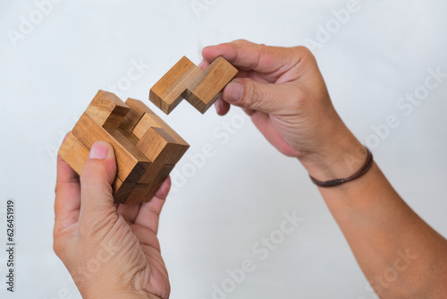 Close up shot of isolated hand playing with wooden cube puzzles photo