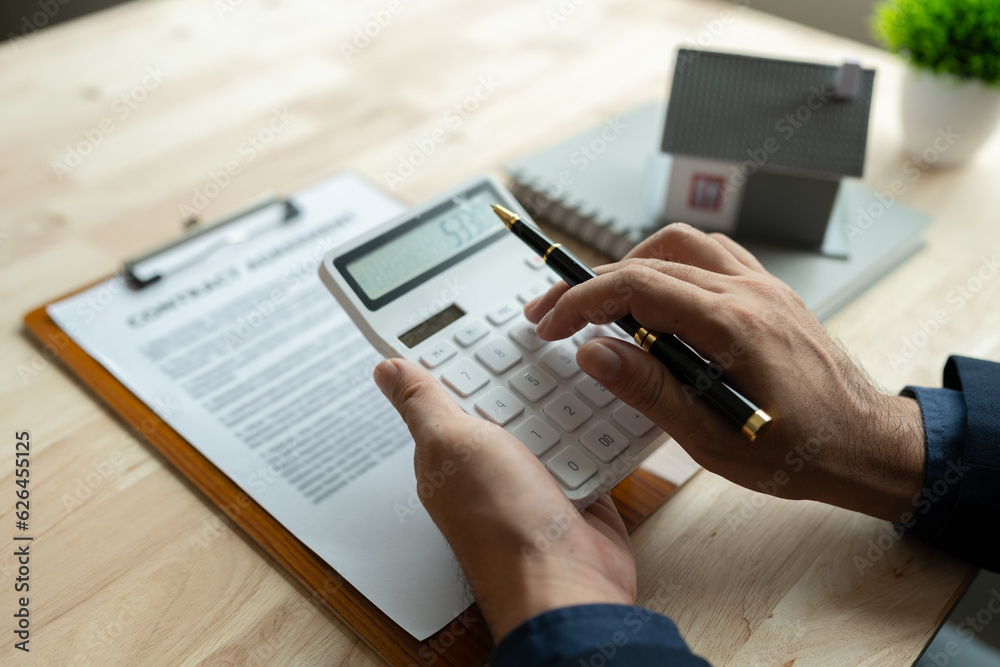 real estate agent, businessman Calculate house prices offered to clients In making a mortgage contract, loan, making a lease, buying a house and home insurance contracts; home mortgage loan concepts real estate agent, businessman Calculate house prices offered to clients In making a mortgage contract, loan, making a lease, buying a house and home insurance contracts; home mortgage loan concepts