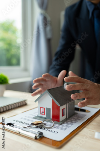 Fotografía Property insurance, real estate broker or home insurance agent gesture protect house, house key, contract document, security concept, protection