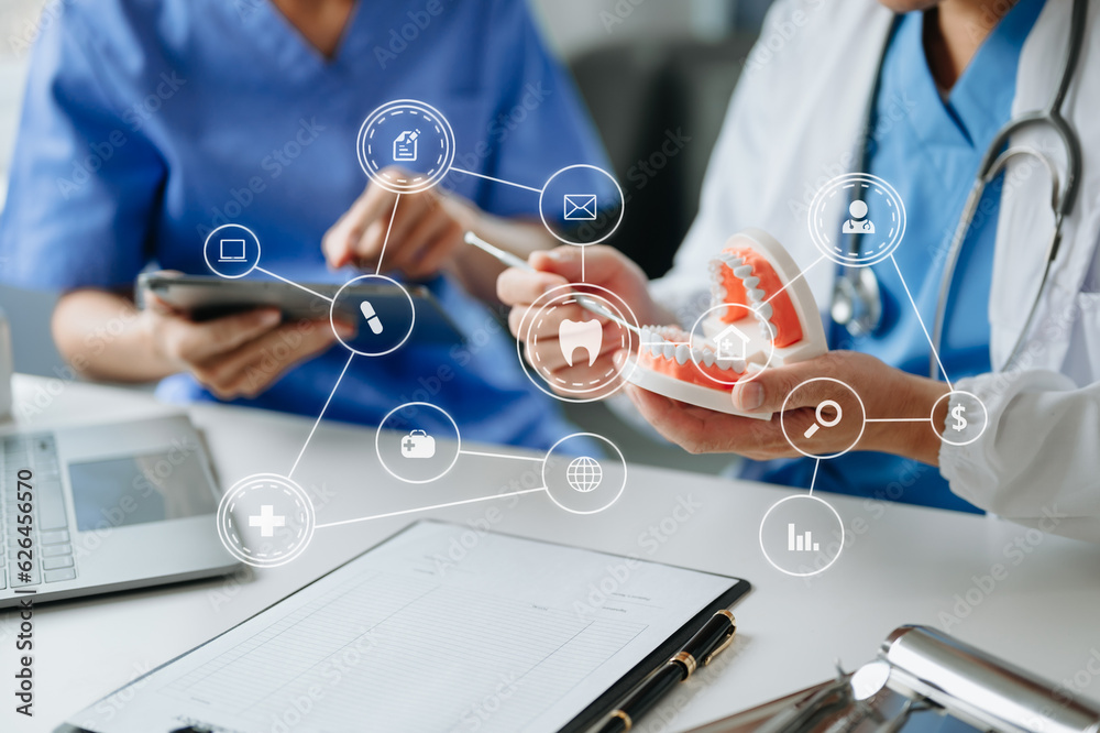 Dentist sitting at table with jaw samples tooth model and working with