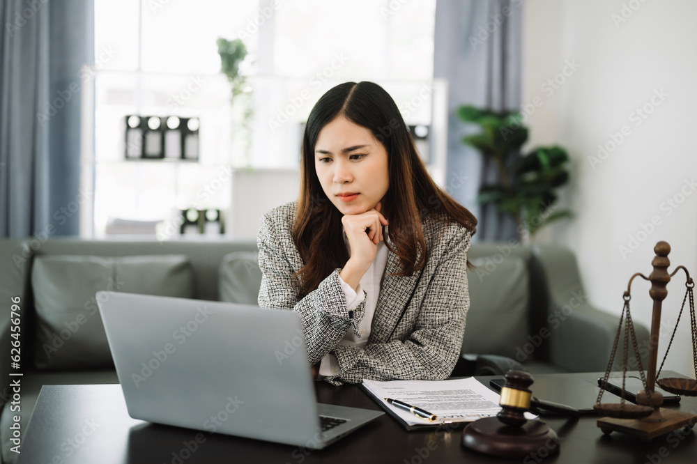 Asian lawyer woman working with a laptop and tablet in a law office. Legal and legal service concept. Asian lawyer woman working with a laptop and tablet in a law office. Legal and legal service concept.